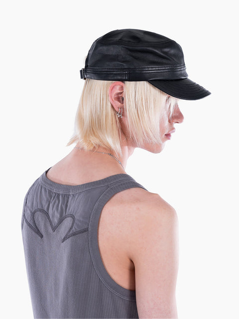 VAIN black lamb leather cap with star deboss and adjustable back strap worn by a model with blonde hair.