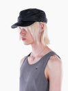 Model wearing a black VAIN lamb leather cap with a star-shaped deboss and logo stitching on the visor.