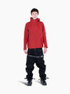 Model wearing a red VAIN shell jacket with heart-shaped yoke, asymmetrical waterproof zippers, and adjustable hood.