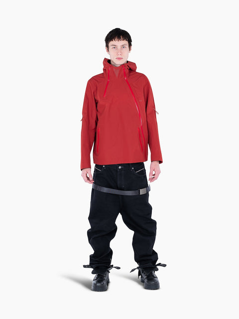 Model wearing a red VAIN shell jacket with heart-shaped yoke, asymmetrical waterproof zippers, and adjustable hood.