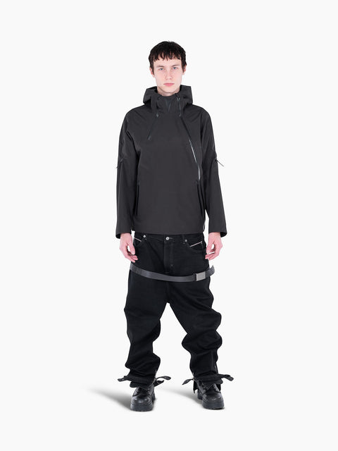 Model wearing a black VAIN shell jacket with a heart-shaped chest yoke, asymmetrical zippers, and a hood.