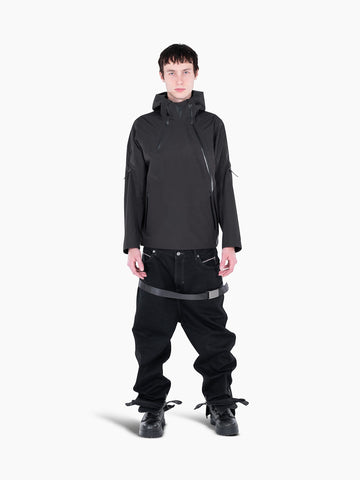 Model wearing a black VAIN shell jacket with a heart-shaped chest yoke, asymmetrical zippers, and a hood.