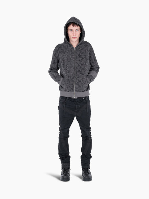 Model wearing a VAIN Skin Hoodie in grey snake-print French terry cotton with a front zipper and rib sleeve detail.