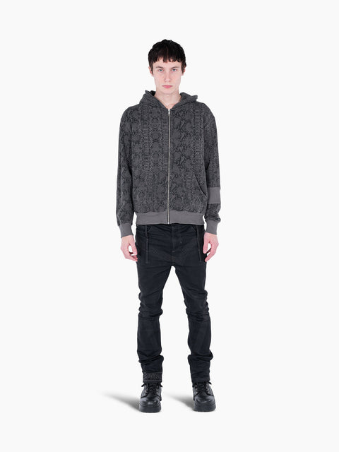 Model wearing a VAIN grey snake print French terry cotton zip-up hoodie with rib sleeve detail and black jeans.